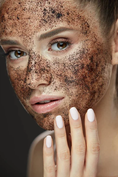 Cuidado com o rosto. Closeup de mulher bonita com esfoliação de café na pele — Fotografia de Stock