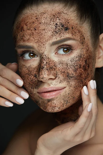 Beauty Face. Retrato de mujer joven poniendo exfoliante de café — Foto de Stock