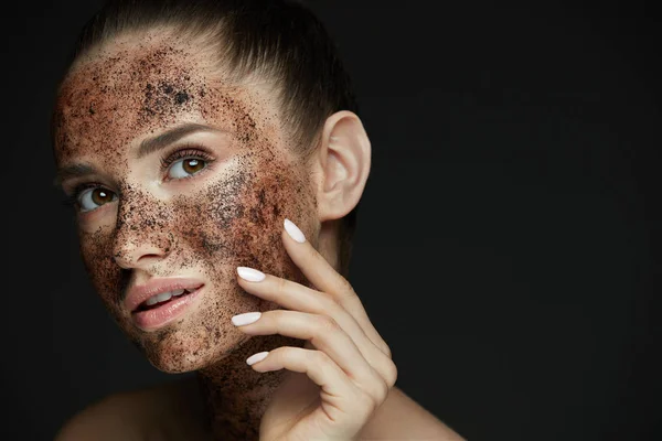 Cuidado facial. Primer plano de mujer hermosa con exfoliante de café en la piel — Foto de Stock