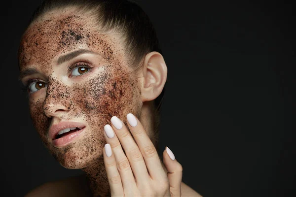 Cuidado facial. Primer plano de mujer hermosa con exfoliante de café en la piel — Foto de Stock