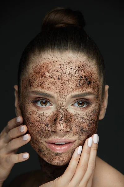 Beauty Face. Retrato de mujer joven poniendo exfoliante de café — Foto de Stock