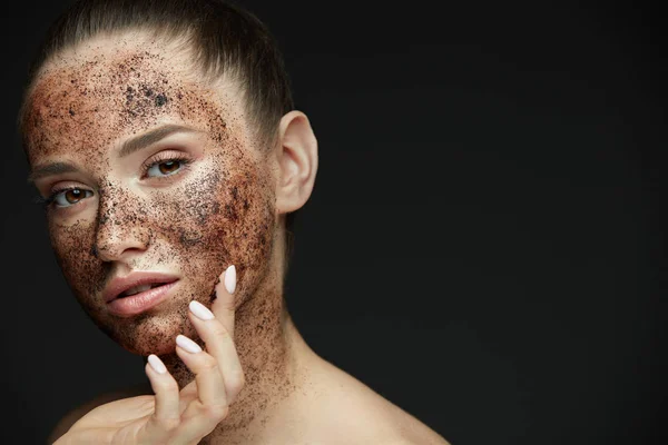 Cuidado facial. Primer plano de mujer hermosa con exfoliante de café en la piel —  Fotos de Stock