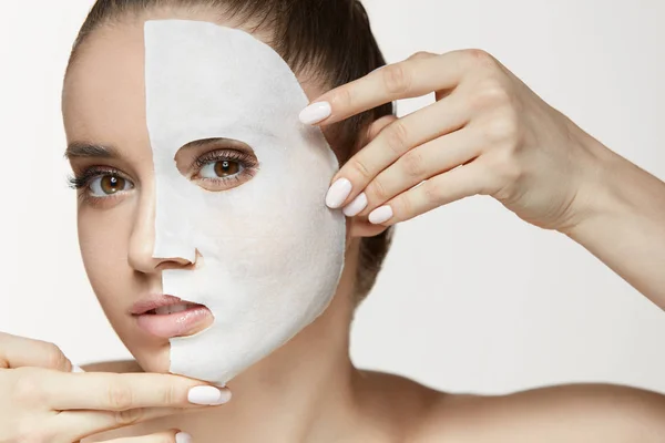 Trattamento viso bellezza femminile della pelle. Donna con maschera di foglio bianco — Foto Stock