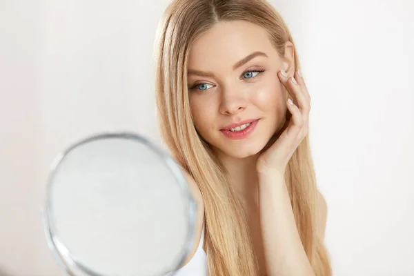 Beauty Face Care. Flicka med frisk hud tittar i spegeln — Stockfoto
