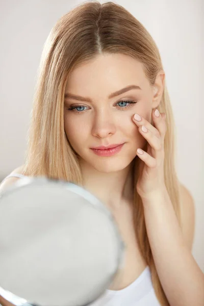 Cuidado facial de belleza. Chica con la piel sana mirando en el espejo — Foto de Stock