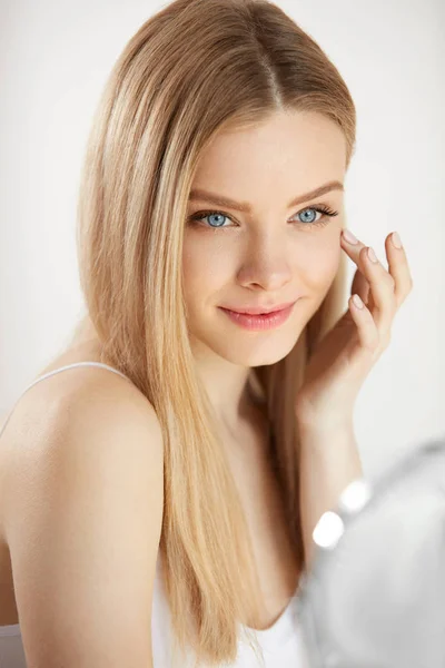 Cura del viso di bellezza. Ragazza con la pelle sana guardando nello specchio — Foto Stock