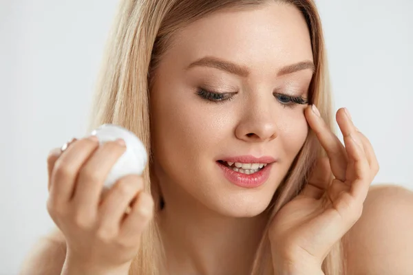 Cuidado facial de belleza. Modelo femenino joven que pone la crema en la piel del ojo — Foto de Stock