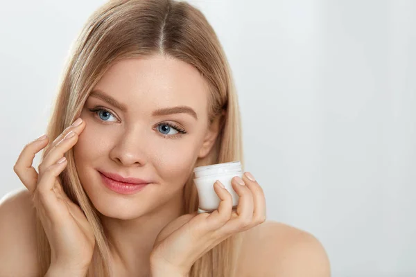 Cosméticos para la piel facial de mujer. Chica aplicando crema bajo los ojos — Foto de Stock