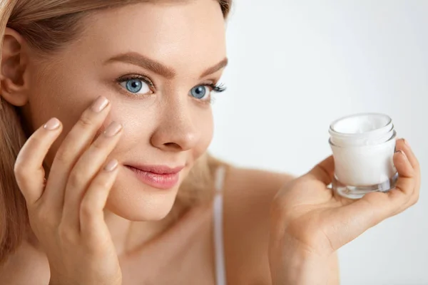 Beauty Woman Face. Girl With Fresh Skin And Cream Bottle In Hand — Stock Photo, Image