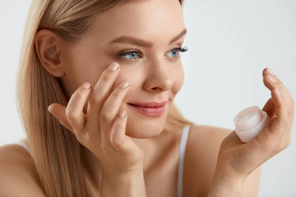 Cosmétiques pour le visage de femme. fille appliquant crème sous les yeux — Photo