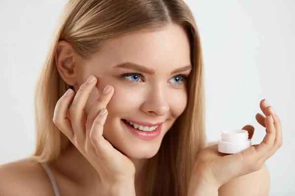 Cosméticos para la piel facial de mujer. Chica aplicando crema bajo los ojos —  Fotos de Stock