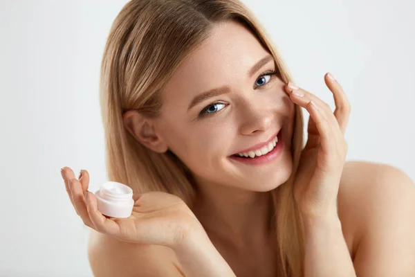Cosméticos para la piel facial de mujer. Chica aplicando crema bajo los ojos — Foto de Stock