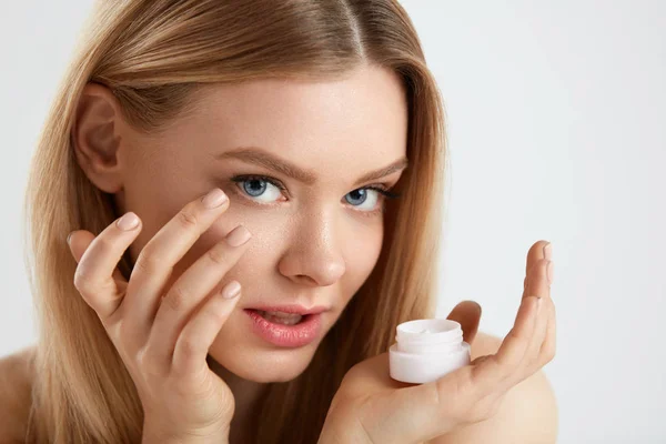 Beauty Face Cosmetics. Linda fêmea colocando creme sob os olhos — Fotografia de Stock
