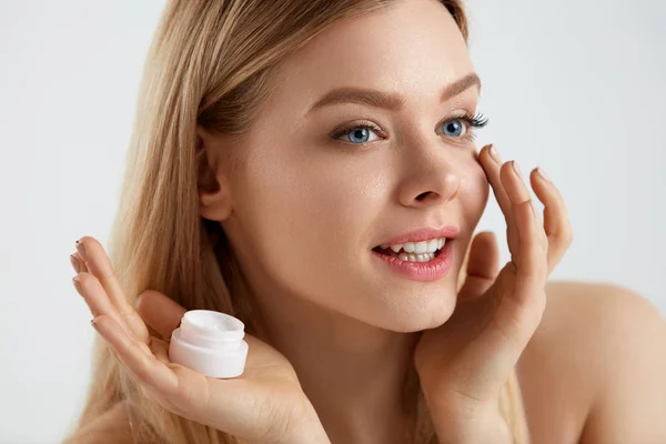 Hermosa mujer aplicando crema en la piel bajo los ojos — Foto de Stock