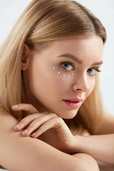 Skönhet kosmetika. Kvinna med droppar av ögonkräm huden på huden — Stockfoto
