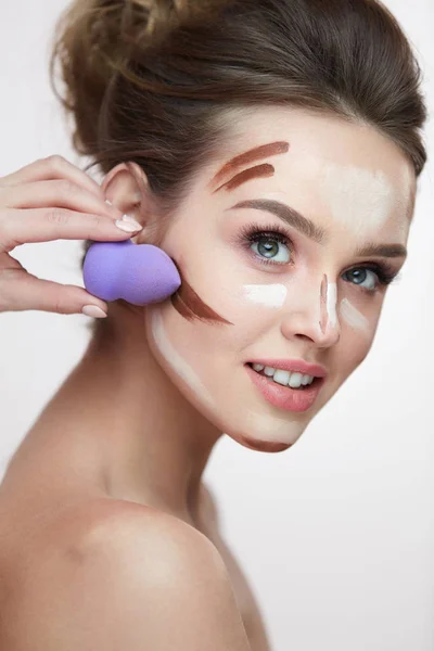 Beleza de maquiagem facial. Linda fêmea aplicando maquiagem com esponja — Fotografia de Stock