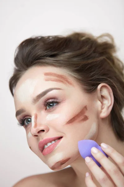 Gezicht make-up schoonheid. Mooie vrouw toepassing van make-up met spons — Stockfoto