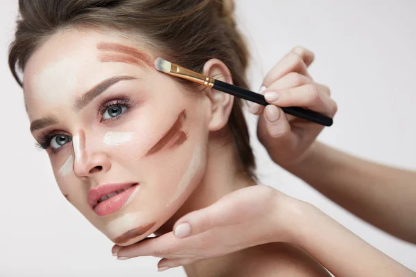 Beauty Make-up. schöne Frau, die Konturlinien auf das Gesicht aufträgt — Stockfoto