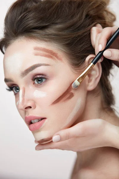 Maquiagem de beleza. Mulher bonita aplicando linhas de contorno no rosto — Fotografia de Stock
