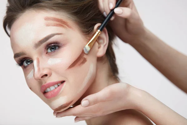 Beauty Make-up. schöne Frau, die Konturlinien auf das Gesicht aufträgt — Stockfoto