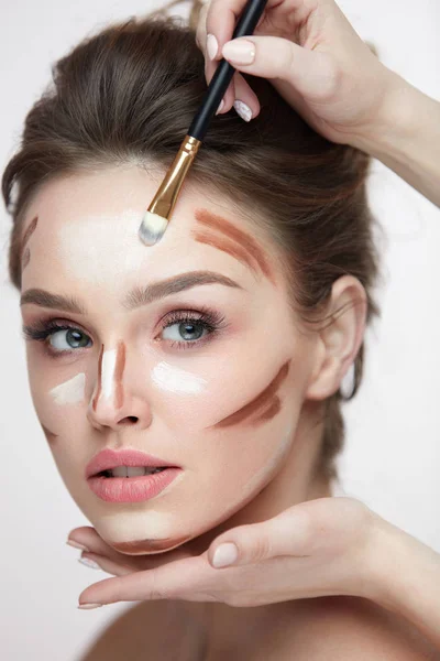 Maquillaje de belleza. Hermosa mujer aplicando líneas de contorno en la cara —  Fotos de Stock