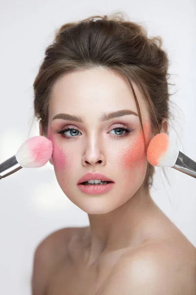 Gezicht Beauty cosmetica. Mooi meisje met make-up toepassing zijn bloost — Stockfoto