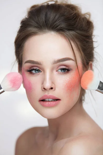 Gezicht Beauty cosmetica. Mooi meisje met make-up toepassing zijn bloost — Stockfoto