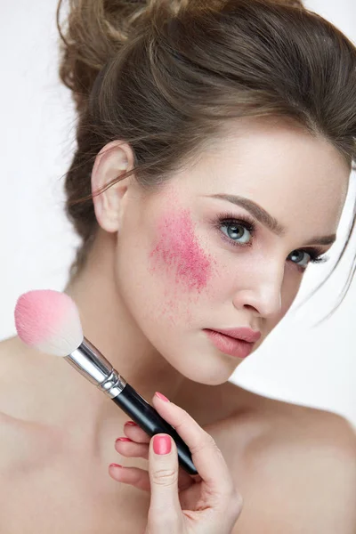 Schoonheid make-up. Closeup vrouw toepassing zijn losse roze bloost op gezicht — Stockfoto
