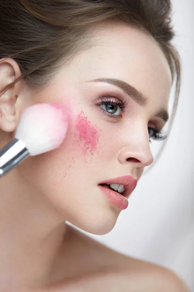 Maquiagem de beleza. Closeup mulher aplicando afrouxamento rosa solto no rosto — Fotografia de Stock