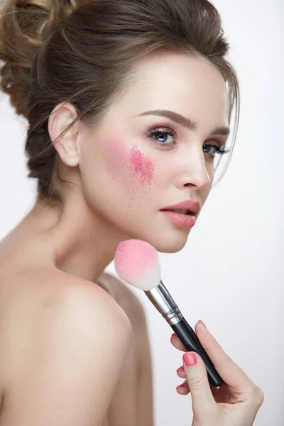 Schoonheid make-up. Closeup vrouw toepassing zijn losse roze bloost op gezicht — Stockfoto