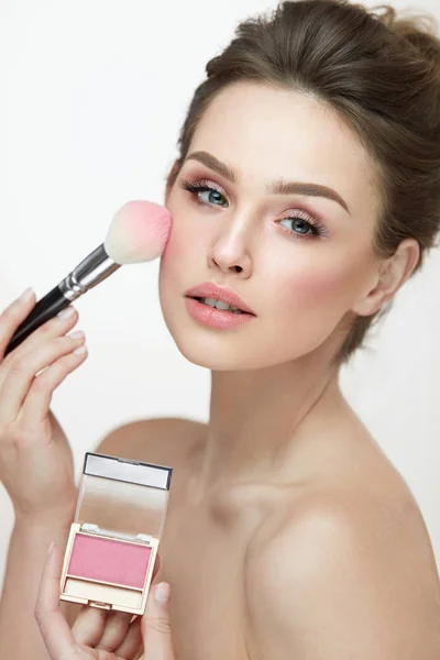 Maquiagem Mulher Face. Fechar as mãos aplicando blush no rosto feminino — Fotografia de Stock