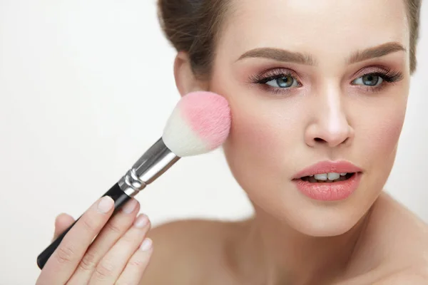 Cosméticos de belleza facial. Sexy mujer aplicando rubor con cepillo — Foto de Stock