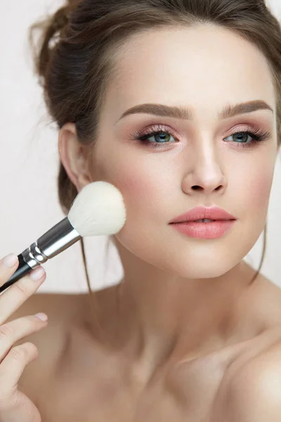 Cosmetici viso trucco. Bella femmina che applica arrossire — Foto Stock