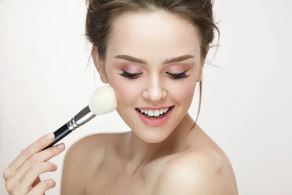 Obličeje make-up. Krásná žena použití tvářenky štětcem — Stock fotografie