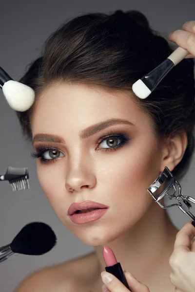 Maquillaje de belleza facial. Primer plano femenino con herramientas cosméticas cerca de la cara —  Fotos de Stock