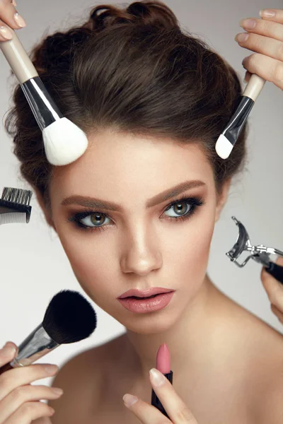 Modeschönheit. Mädchen mit glamourösem Make-up und Bürsten im Gesicht — Stockfoto