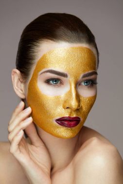 Kozmetik ürün. Altın maske yüz dokunmadan ile güzel kız