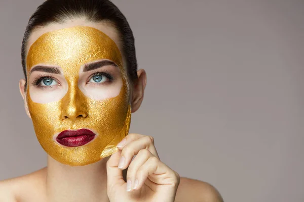 Schoonheidsproduct. Close-up van Sexy vrouw gouden masker verwijderen — Stockfoto