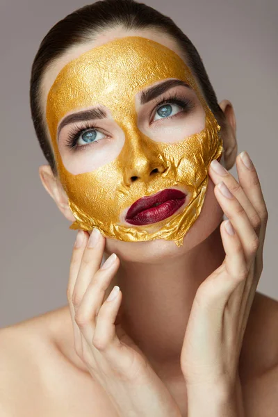 Kosmetik Kulit Wajah. Perempuan Dengan Wajah Membelai Topeng Emas — Stok Foto