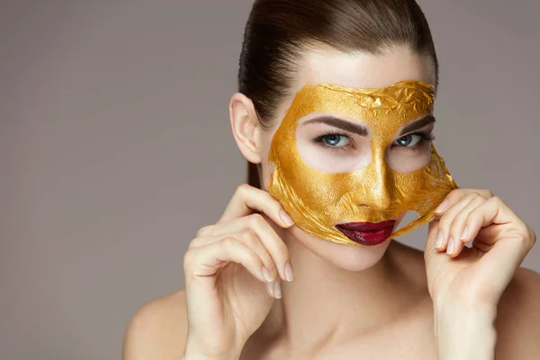 Cosmétiques de beauté. Femme Enlever Masque D'or Du Visage Avec Les Mains — Photo