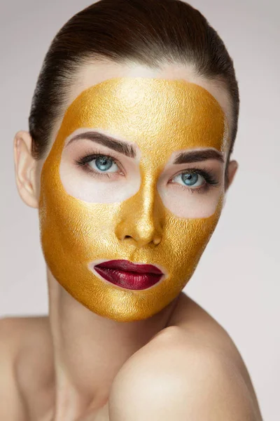 Vrouw gezicht behandeling. Aantrekkelijke vrouw met schoonheid Golden Mask — Stockfoto