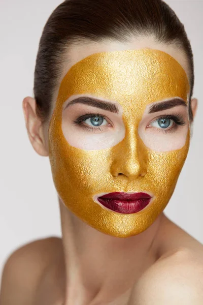 Kosmetyki. Młoda kobieta z złota maska na miękkiej skóry — Zdjęcie stockowe