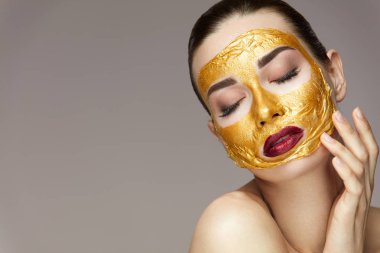 Kozmetik ürün. Altın maske yüz dokunmadan ile güzel kız