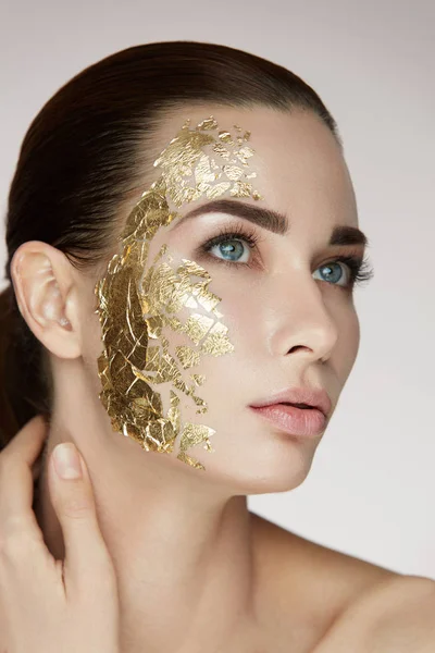 Weibliche Hautpflege. Weibchen mit goldener Maske im Gesicht — Stockfoto