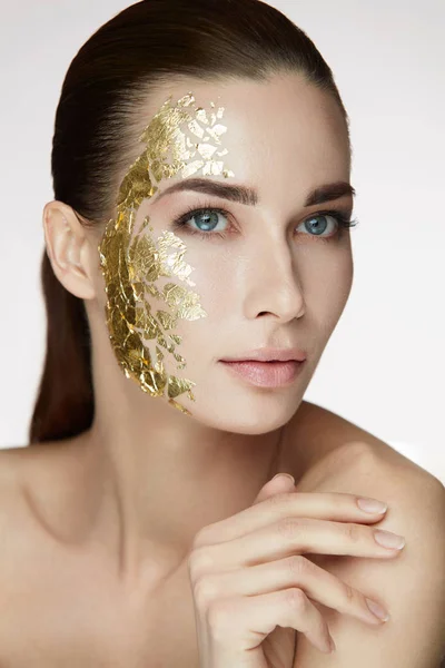 Weibliche Hautpflege. Weibchen mit goldener Maske im Gesicht — Stockfoto