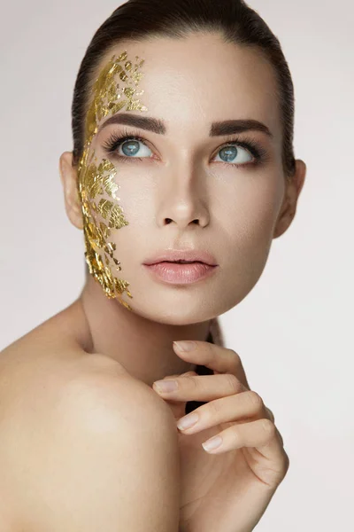 Vrouwelijke huidverzorging. Vrouw met gouden masker op het gezicht — Stockfoto