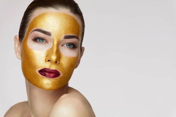 Zabieg na twarz kobiety. Atrakcyjna kobieta z Beauty Golden maska — Zdjęcie stockowe