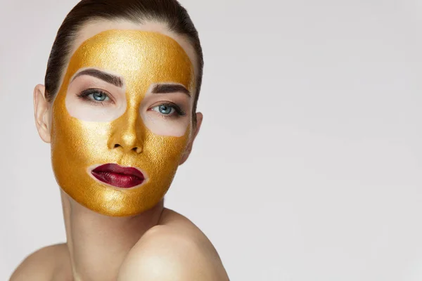 Vrouw gezicht behandeling. Aantrekkelijke vrouw met schoonheid Golden Mask — Stockfoto