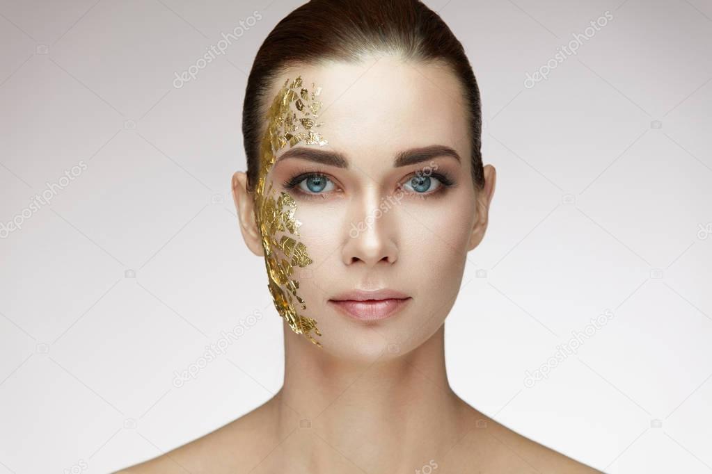 Beauty Woman Face. Young Female With Gold Mask On Soft Skin