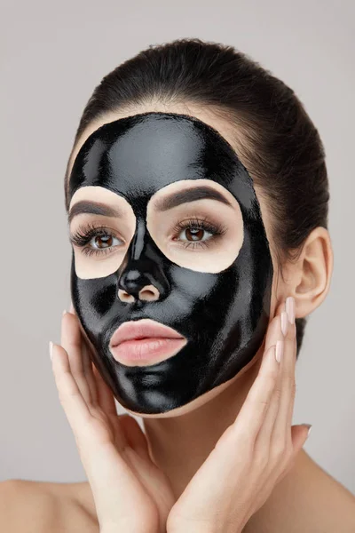 Mulher Beauty Face Care. Menina aplicando máscara de descascamento preto na pele — Fotografia de Stock